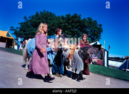 Le ragazze con i pony alla fiera medievale di camp. Foto Stock