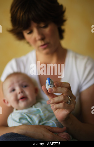 Madre tenendo la temperatura del malato bambino di 6 mesi boy Foto Stock