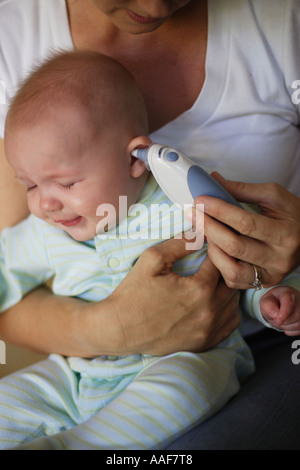 Madre tenendo la temperatura del malato bambino di 6 mesi boy Foto Stock