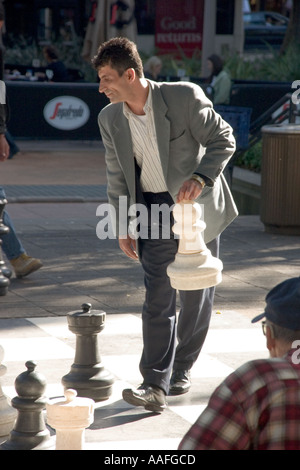 L'uomo gioca a scacchi sul set di gigante di Sydney s Hyde Park Foto Stock