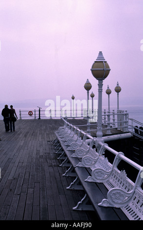 Paio di passeggiare lungo il molo in legno porto di Torquay Foto Stock