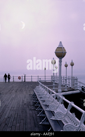 Paio di passeggiare lungo il molo in legno porto di Torquay Foto Stock