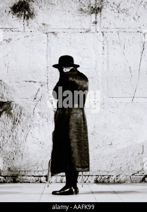 Un Ebreo in preghiera presso il sacro ebraico religioso sito storico del Muro del Pianto o Muro Occidentale di Gerusalemme in Israele Palestina in Medio Oriente Foto Stock