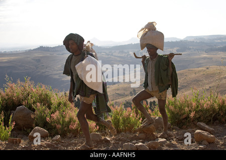 Due uomini tornare indietro a piedi dal mercato di sbarcare in Simien Mountains Etiopia Africa Foto Stock