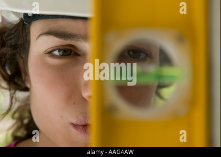 Costruzione femmina lavoratore con livello di edificio Foto Stock