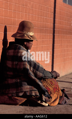 Un senzatetto quechuia parlando donna si siede accanto alla strada mendicando Puno, il lago Titicaca Perù Sud America Foto Stock