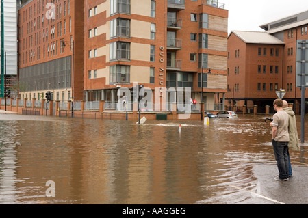 Inondati Fiume Aire a curiosi Nettuno Street & East Street Leeds con vetture sommersa al di fuori di una Trinità appartamenti Giugno 2007 Foto Stock