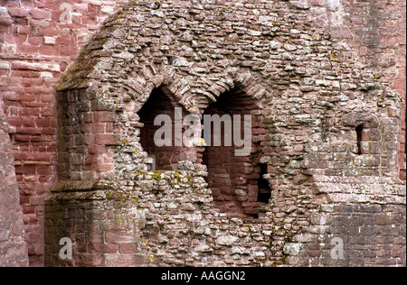 Goodrich Castle in Herefordshire - finestra di vetro colorato e parte delle mura del castello che mostra gli effetti degli agenti atmosferici in arenaria rosa. Foto Stock