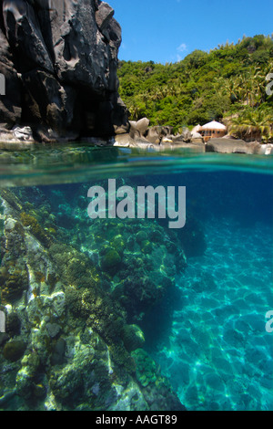 Oltre sotto immagine della barriera corallina e local resort circondato da alberi e rocce Apo Riserva Marina Isola Filippine Foto Stock