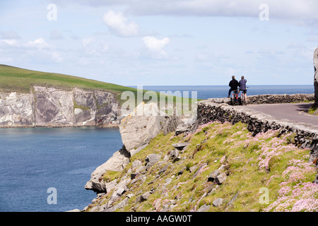 L'Irlanda Kerry Penisola di Dingle Slea Head ciclisti sulla strada costiera che cercano di Dunmore Head Foto Stock