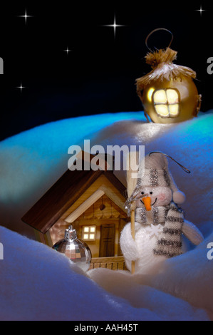 Natale artistico ancora in vita di un pupazzo di neve vicino ad una casa in legno Xmas inverno vacanze inverno Foto Stock