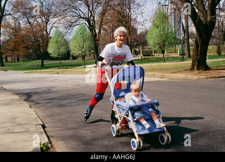 Nonna portante 9 nipotini dodici mesi in baby buggy Foto Stock