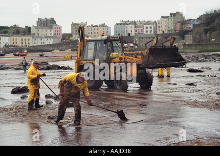 I contraenti pulire Tenby Beach dopo la petroliera Sea Empress si è arenata sulle rocce vicino Milford Haven fuoriuscita di 72000 tonnellate di olio Foto Stock