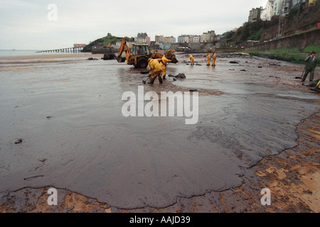 I contraenti pulire Tenby Beach dopo la petroliera Sea Empress si è arenata sulle rocce vicino Milford Haven fuoriuscita di 72000 tonnellate di olio Foto Stock