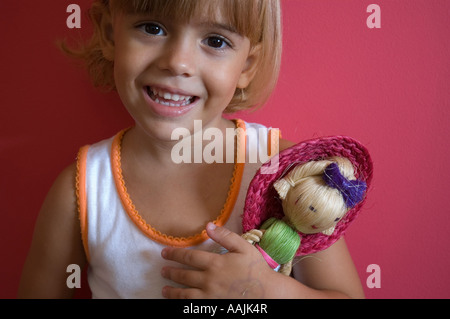 Ritratto di una ragazza con una bambola e sorridente Foto Stock