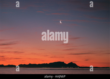 Cielo di tramonto e luna nuova sulla Table Mountain presi da False Bay Città del Capo Sud Africa Foto Stock