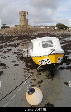 Spiaggiata barca sulla spiaggia di fronte al mastio della seconda guerra mondiale a St Clements bay in Jersey Foto Stock