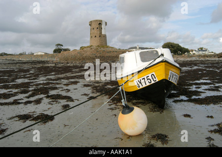 Spiaggiata barca sulla spiaggia di fronte al mastio della seconda guerra mondiale a St Clements bay in Jersey Foto Stock