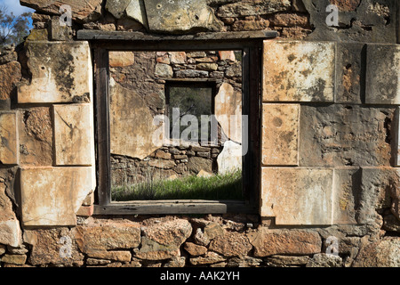 Vista attraverso i telai di finestre sulle rovine di un coloniale abbandonato homestead nella campagna australiana Foto Stock