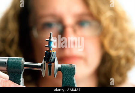 Donna ingegnere azienda microscopio componente di misurazione Foto Stock