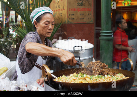 La donna la cottura nel wok da strada Foto Stock