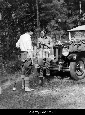 1920s 1930 GIOVANE UOMO DONNA negli attrezzi da pesca il sostegno dei pali IN PIEDI NELLA PARTE ANTERIORE DEL PACKARD TOURING AUTOMOBILE Foto Stock