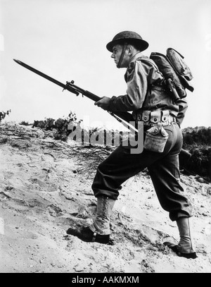 1940s 1942 II GUERRA MONDIALE soldato camminare su terreni accidentati con un fucile e baionetta IN MANO Foto Stock