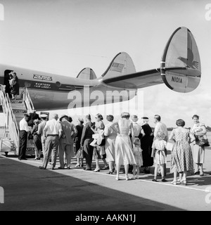 Anni Cinquanta la coda di aviazione commerciale aereo su asfalto CON I PASSEGGERI IN LINEA IN ATTESA DI BORDO Foto Stock