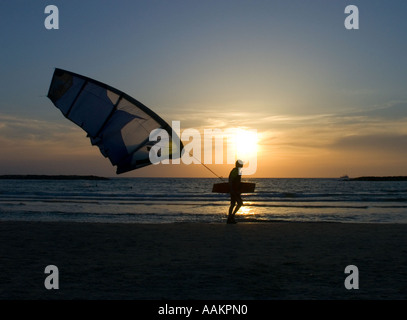 Uomo che cammina con un aquilone di trazione in riva al Mar Mediterraneo di Tel Aviv in Israele Foto Stock