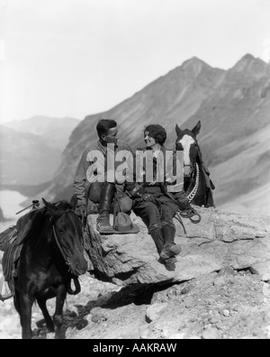 1920s 1930 giovane seduto sulle rocce HOLDING Redini di sentiero cavalli Foto Stock