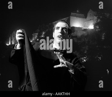 Anni Settanta HALLOWEEN Ritratto notturno di uomo che indossa il capo e zanne vestito come Dracula il vampiro Foto Stock