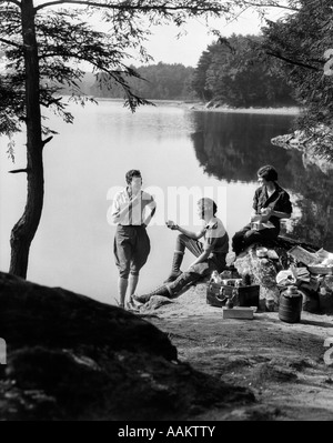 1920s 1930 3 persone fare picnic da ONATA LAGO uomo che indossa i jodhpurs permanente inserito due donne BERKSHIRES MA USA Foto Stock