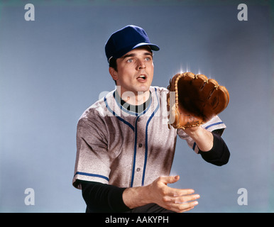 Anni sessanta giovane uomo in uniforme da baseball tenendo fuori GUANTO ALLA SFERA DI CATTURA MITT READY ALERT Foto Stock