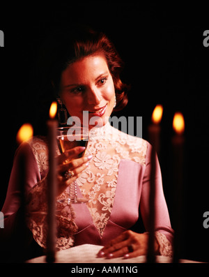 Negli anni settanta la donna elegante abito da sera LACY abbigliamento formale TENUTA A LUME DI CANDELA IN VETRO CHAMPAGNE ROMANCE ROMANTICO Foto Stock