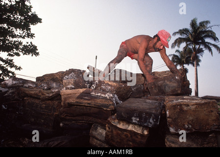 L'Amazzonia, Brasile. I lavoratori della gomma di caricamento nel carrello. Esportazione delle risorse naturali Foto Stock