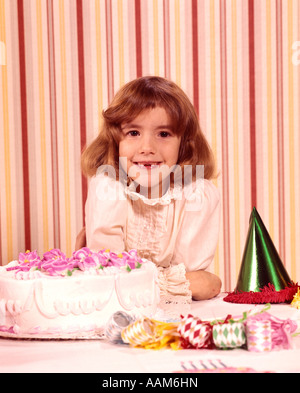 1970 anni settanta ritratto sorridente ragazza mancanti denti anteriori torta di compleanno i favori del partito felice celebrazione celebrare le parti Foto Stock