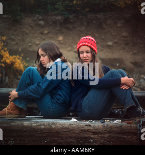 1970 anni settanta retrò ragazzo adolescente e la ragazza seduta DI SCHIENA AL DI FUORI Foto Stock