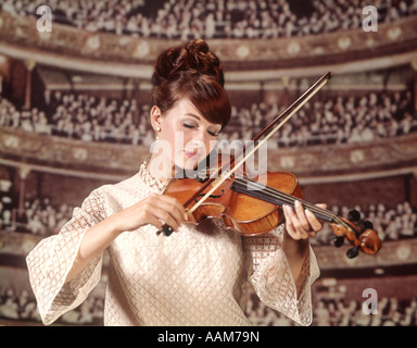 1960 anni sessanta donna violinista suona il violino bianco usura Abito in pizzo pubblico CONCERT HALL sfondo visibile le donne Foto Stock