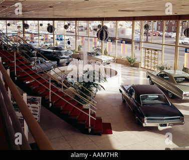Anni sessanta VISTA INTERNA DELL'AUTOMOBILE SHOWROOM con pareti in vetro e tappeto rosso sulla scaletta Foto Stock