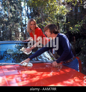 1970 anni settanta coppia GIOVANE DONNA UOMO lavare lavaggio rosso tergivetri auto parabrezza Foto Stock