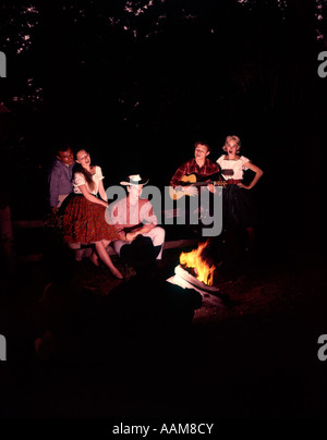 1960 1960 1970 anni settanta le coppie uomini donne uomo donna seduta a cantare intorno al falò notte country western Foto Stock
