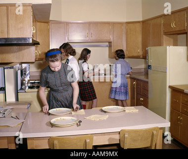 1960 1960 4 ragazze STUDENTI IN CUCINA HOME Economia la classe nella tabella di impostazione di educazione di cottura retrò Foto Stock