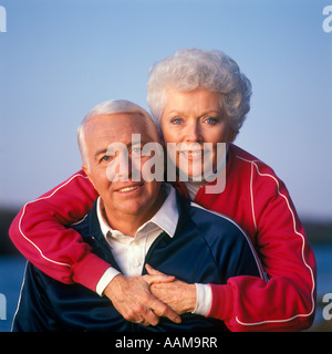 Ritratto di giovane in tute da jogging donna in piedi con le braccia intorno all'uomo Foto Stock