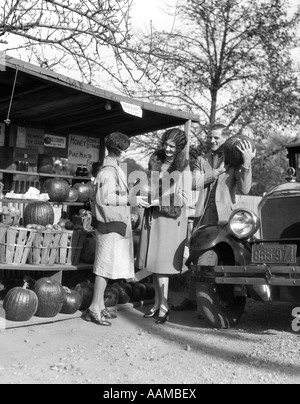 1920s GIOVANE DONNA UOMO A PRODURRE STRADALE STAND Acquisto di zucche Foto Stock