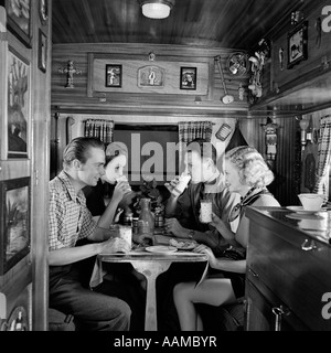 Negli anni Trenta due coppie seduti all'interno del camping trailer di mangiare il pranzo Foto Stock
