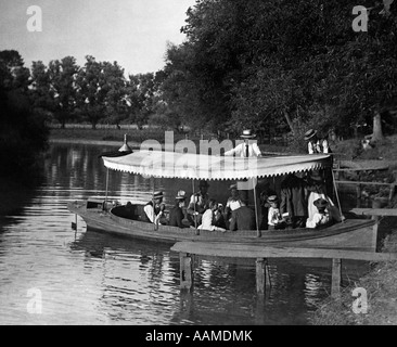 1890s 1900 svolta del secolo GRUPPO IN BARCA con la tettoia essendo spinto fuori in lago Foto Stock