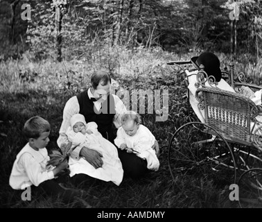 1890s 1900 svolta del secolo padre seduto in boschi con tre bambini bambino trasporto OFF A LATO Foto Stock