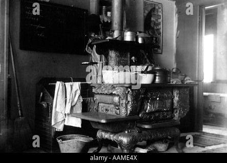 1890s 1900 GIRO DEL SECOLO GHISA legno bruciando fornello con pentole e padelle IN CUCINA Foto Stock