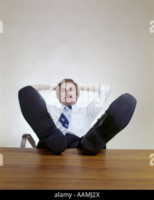 Uomo seduto office desk piedi rilassante i baffi 1970 anni settanta retrò Foto Stock