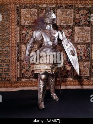 A piena lunghezza completa armatura medievale casco spada scudo metallico di cavalleria del Cavaliere Battaglia guerriero vestito arazzo araldico Foto Stock